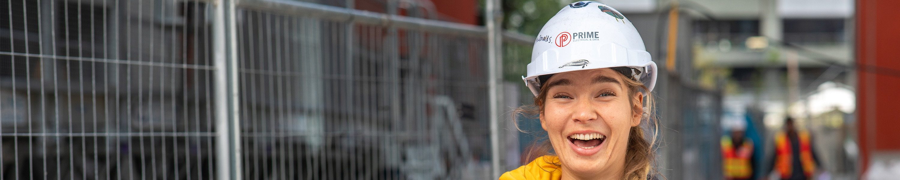 Female tradie on worksite wearing white hardhat