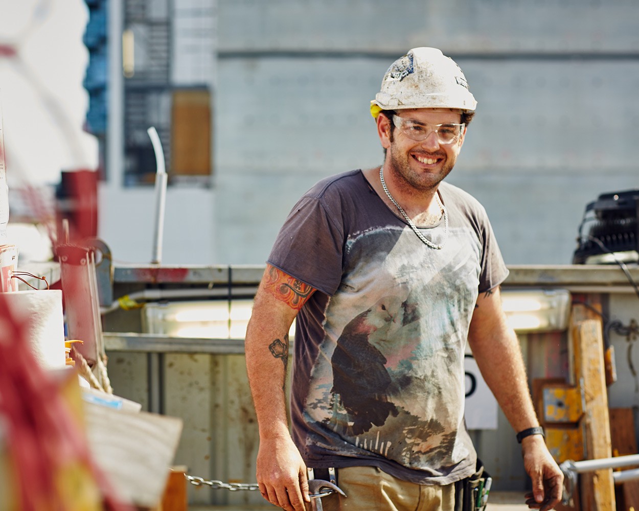 A construction worker sawing wood